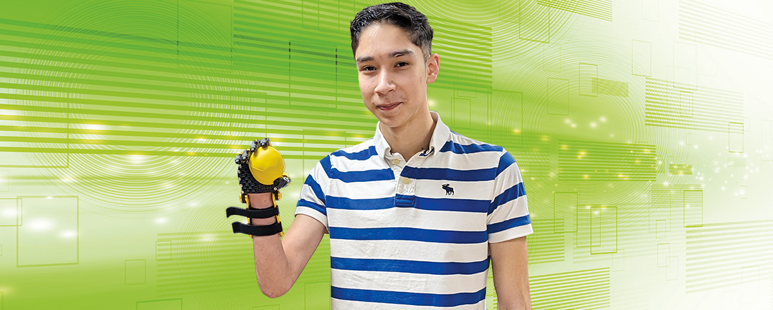 Image of a teen with a 3D printed hand, holding a ball