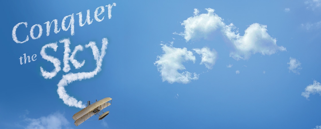 Image of a plane with writing in the sky, "Conquer the Sky"